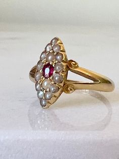 * Valued in 2022 at $2750 * On offer for you is an original antique Victorian navette ring in 18k/18ct solid yellow gold. It features a deep red ruby with a lot of vibrancy centered in an eye shape setting surrounded by creamy seed pearls. Scrolling split shoulders hold the petite ring face, and taper away to a 1.61mm band with a domed profile. On the band is an array of hallmarks including the letter R dating this ring for the year 1891, manufactured in Birmingham by S & CO. 🌟Please check out Antique 14k Gold Marquise Ring, Heirloom Oval Pearl Ring With Rose Cut Diamonds, Heirloom Oval Pearl Ring, Heirloom 14k Stamped Oval Pearl Ring, Vintage Marquise Ruby Wedding Ring, Marquise Ruby Ring In Yellow Gold For Wedding, Antique Oval Pearl Ring Stamped 14k, Heirloom Yellow Gold Marquise Rings, Vintage Marquise Cut Ruby Ring In Yellow Gold