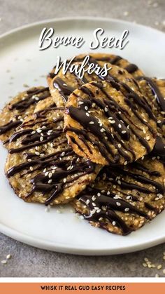 some cookies with chocolate drizzled on top are sitting on a white plate