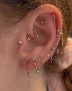 a close up of a person's ear with different types of piercings on it