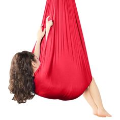 a woman laying in a red hammock with her legs hanging over the top