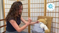 a woman sitting on a chair with a teddy bear