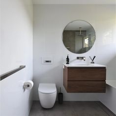 a bathroom with a toilet, sink and mirror in it's center wall area