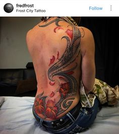 a woman sitting on top of a bed with her back turned to the camera and tattoos