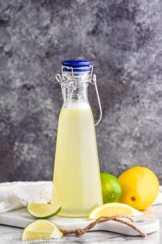 lemonade in a glass bottle with limes around it