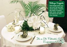 the table is set with white flowers and place settings