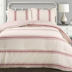 a bed with white and red striped comforter