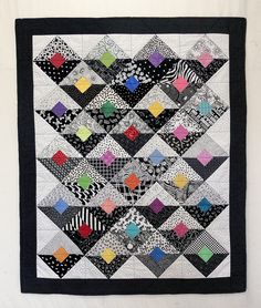 a black and white quilt hanging on the wall