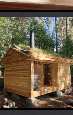 a small wooden cabin with a green roof