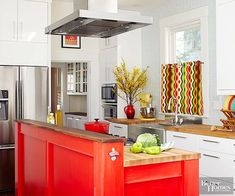 a kitchen with white cabinets and red island