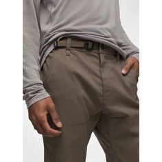 a man in grey shirt and khaki pants with his hand on his hip