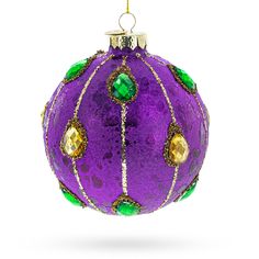 a purple ball ornament with green and gold trimmings, hanging on a white background