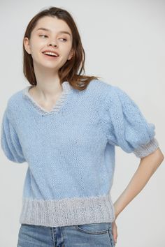 a woman wearing a blue sweater and jeans