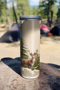 a stainless steel tumbler with an image of a deer in the woods on it