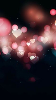 the blurry image shows many hearts in pink and red colors, as well as black background