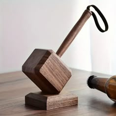 a wooden hammer and beer bottle holder on a wood floor