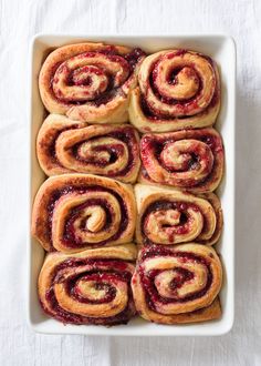 a white dish filled with pastries on top of a table