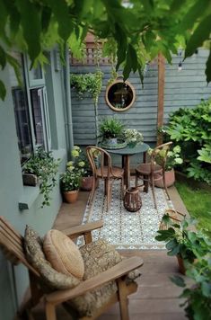 an outdoor patio with chairs, table and potted plants