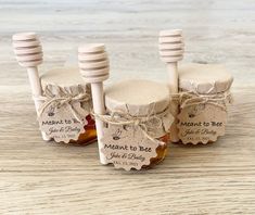 three honey jars with wooden spoons tied together