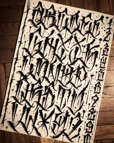 an old fashioned type of calligraphy is displayed on a wooden surface with black ink