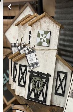 several birdhouses are hanging on a wooden shelf next to pictures and frames in the shape of houses