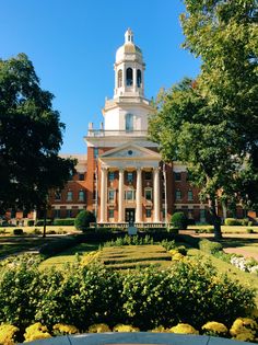 a large building with a clock tower in the middle of it's front yard