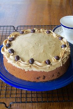 a cake on a blue plate next to a cup and saucer