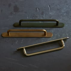 two handles and one door handle are on the floor next to each other, both brass or black