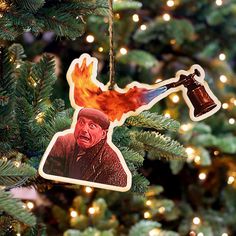 a christmas ornament hanging from a tree with a photo of a man on it