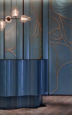 a tall blue vase sitting on top of a wooden floor next to a light fixture