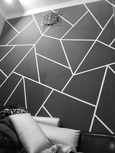 a black and white photo of a living room with geometric wallpaper on the walls