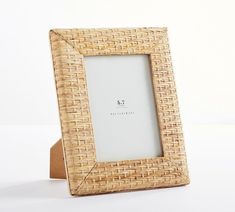 a wooden frame with a woven pattern on the front and bottom, sitting on a white surface