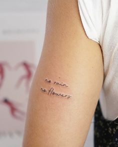 Small Fine Line Tattoo Quotes, Small Word Tattoos For Women Arm, Bicep Word Tattoo Women, 1 Word Tattoos For Women, Rib Wave Tattoo, Strength Quote Tattoo, Feminine Quote Tattoos, Small Tattoos For Strength, Quarter Size Tattoos For Women