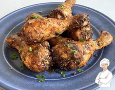 a blue plate topped with chicken wings covered in herbs