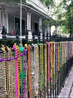 a row of black iron fence covered in lots of beads