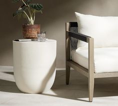 a white chair sitting next to a potted plant