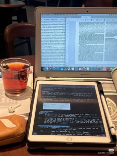 an open laptop computer sitting on top of a table next to a cup of tea