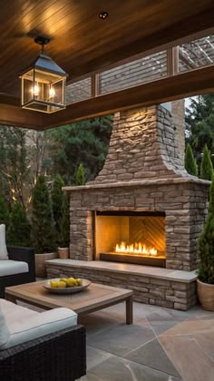 an outdoor fireplace is lit up in the evening