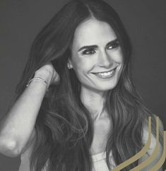 a black and white photo of a woman with long brown hair smiling at the camera