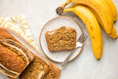 two slices of banana bread on plates next to bananas