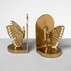 two golden butterfly bookends are next to each other