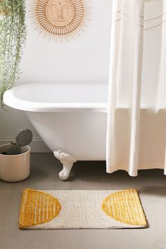 a white bath tub sitting next to a yellow rug