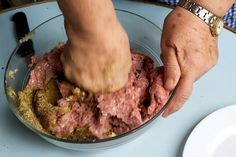 a person mixing food in a bowl on top of a table