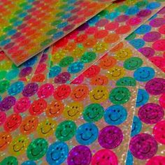 rainbow sequinized smiley face stickers are on top of each other, with different colors