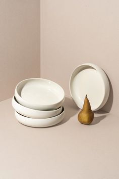 three plates and a pear on a table