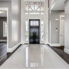 an empty hallway with white walls and wood flooring is seen in this image from the front door