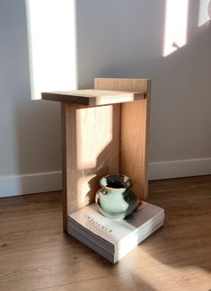 a small wooden shelf with a bowl in it on top of a hard wood floor