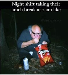 a man sitting on the ground with a bag of chips in front of his face