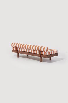 an orange and white striped bench with wooden legs