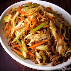 a white bowl filled with cabbage and meat