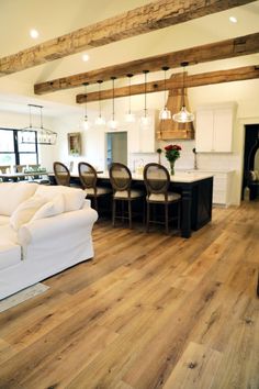 a living room filled with furniture next to a kitchen